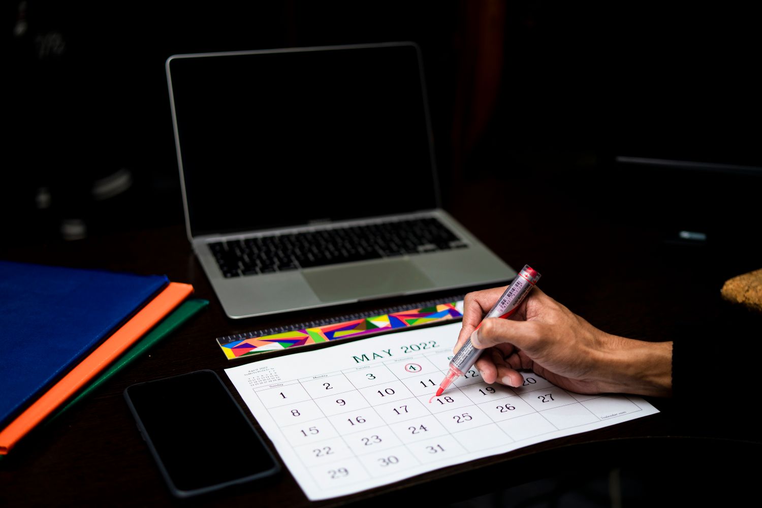 A person marking a paper calendar at a desk in Durban, South Africa