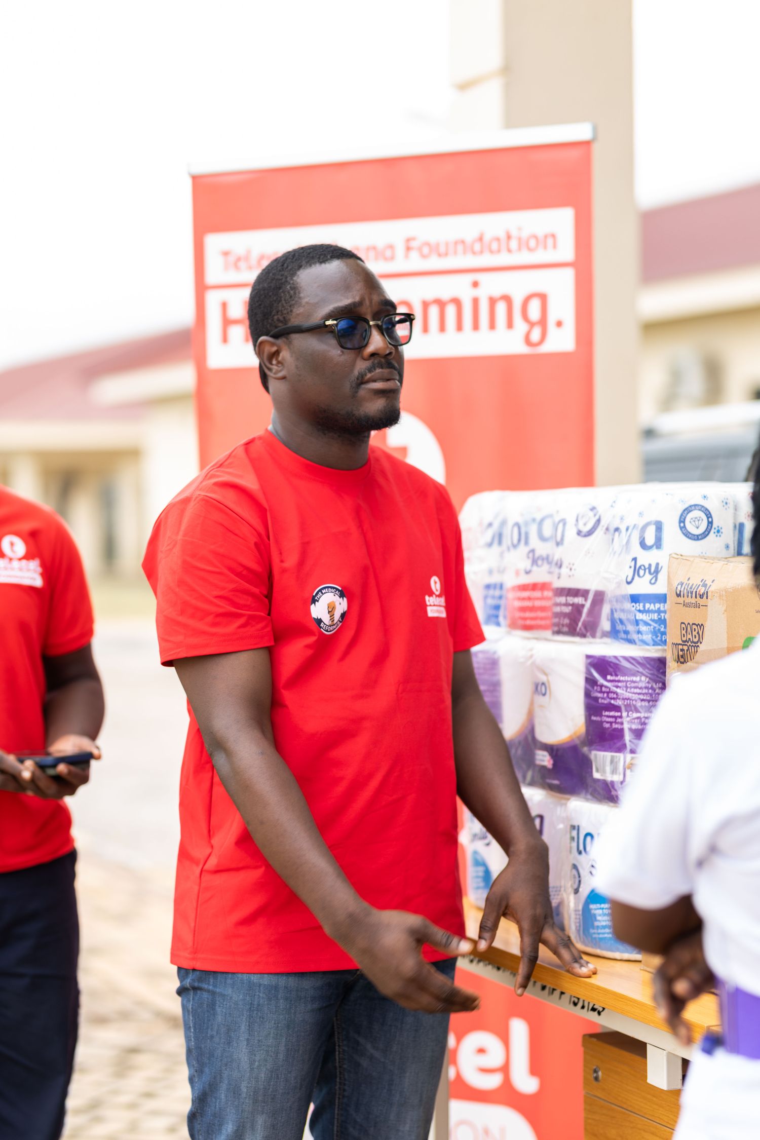 A volunteer handing out supplies at a community outreach event